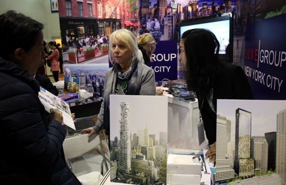 A New York property project display at an international housing exhibition in Beijing attracts investors. Continually rising prices and tightening measures are pushing more Chinese investors to seek opportunities overseas. [Photo / China Daily]