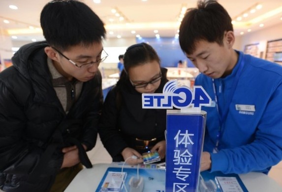 Salesman explaining 4G mobile phones at a Samsung outlet in Beijing, on Jan 2, 2014. [Photo / Xinhua]  