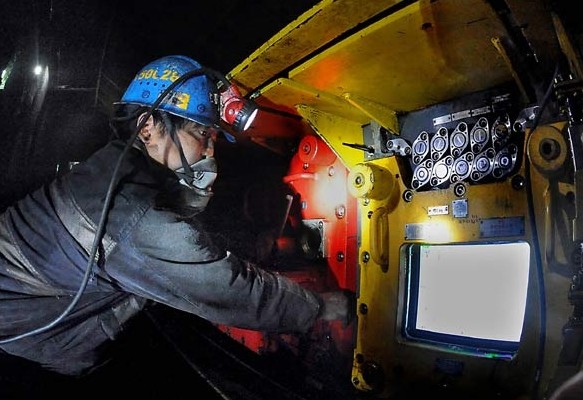 A technician inspects coal-mining machines at a Shaanxi Coal Industry Co branch. China's third-largest coal miner raised 4 billion yuan in its IPO on Tuesday, which was only about 40 percent of the company's projections. [Photo by Wang Song / Xinhua]  