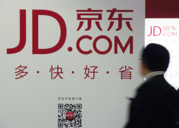 A man walks past an adevertisement for JD.com in Nanjing, capital of East China's Jiangsu province on June 12, 2013.[Zhen Huai / Asianewsphoto]