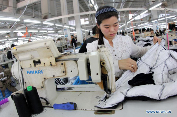 A woman works in a clothing factory at Shahe Town of Ganyu County in Lianyungang City, east China's Jiangsu Province, Oct 13, 2013. (Xinhua file photo)