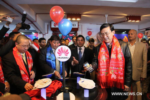 Chinese Ambassador to Nepal Wu Chuntai (R Front) tries a new mobile phone during the launching program of Huawei mobile phone store in Katmandu, Nepal, Feb. 4, 2014. Huawei, a Chinese global information and communications technology (ICT) solutions provider, officially entered into Nepal's market on Tuesday. (Xinhua/Tang Wei)