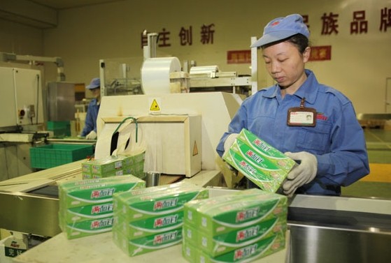 A worker bundles packages at the toothpaste production line of Liuzhou Liangmianzhen Co Ltd in Guangxi Zhuang autonomous region. Huo Yan / China Daily   