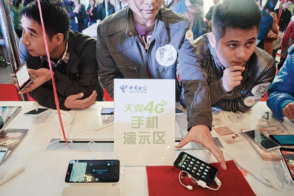 Visitors try out China Telecom 4G phones at an exhibition in Changsha, Hunan province. China Telecom has become the nation's second telecom operator to offer 4G services. It plans to start 4G businesses in close to 100 cities across the country. Provided to China Daily 