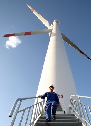 A worker at a wind turbine in Xinjiang Uygur autonomous region. China will remain the leading global consumer of wind turbine rotor blades over the coming years, with its market value expected to increase from $2 billion in 2012 to $3.7 billion by 2020.[Photo/China Daily]