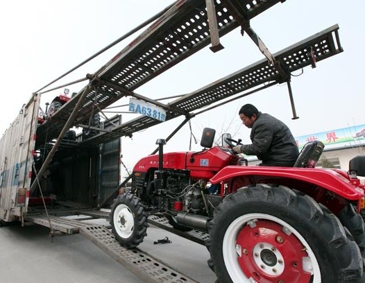 Tractors are loaded in Tengzhou, Shandong province, for delivery to dealers and customers in northeastern China. The flash estimate for the manufacturing Purchasing Managers' Index for February slid to a seven-month low of 48.3, HSBC Holdings Plc said on Thursday. SONG HAICUN/XINHUA   