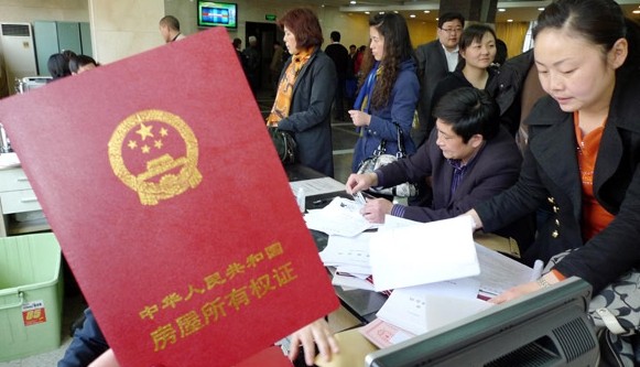 Potential home purchasers complete mortgage applications at a real estate transaction center in Nanjing, Jiangsu province. LIU LI / FOR CHINA DAILY  