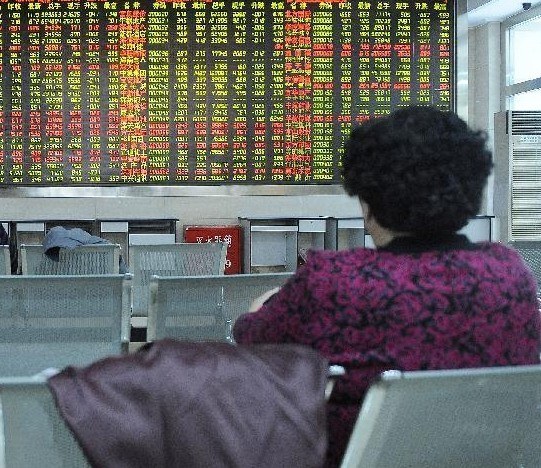 Investors look through stock information in the trading hall of a securities firm in Yinchuan, capital of northwest China's Ningxia Hui Autonomous Region, Feb. 24, 2014. (Xinhua/Li Ran)
