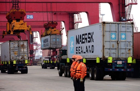 Workers move containers at a port in Qingdao, the capital of Shandong province. China's total foreign trade in January unexpectedly surged 10.3 percent year-on-year, with exports up 10.6 percent and imports up 10 percent. Provided to China Daily   