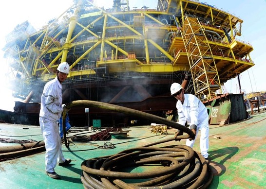 China National Offshore Oil Corp workers move cables on an offshore oil drilling platform. In January, Iceland's energy authority granted CNOOC and its partners a new exploration license. YU FANGPING / FOR CHINA DAILY  