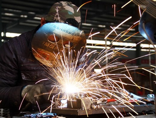A welder assembles strollers at a factory in Zaozhuang, Shandong province. China's manufacturing PMI was 50.2 in February, a decline from 50.5 in January. Provided to China Daily   