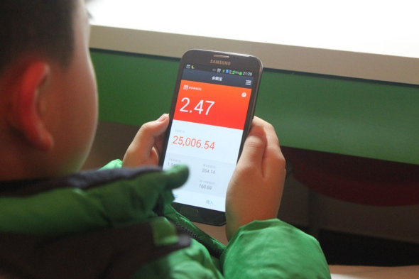 Jerry Jiang, a 9-year-old Shanghai primary school pupil, checks the rate of return on Yuebao, an online mutual fund.  Jiang Jun 