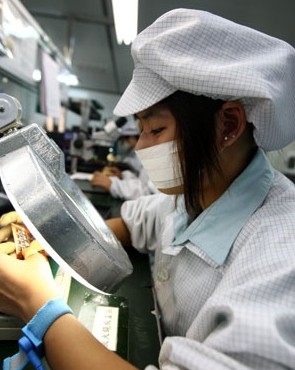 A worker checks the circuit chip at a display manufacturing plant in Dongguan, Guangdong province. The city, known as a manufacturing hub in the country and the world, is aiming at sustainable economic growth. Chen Fan / for China Daily 