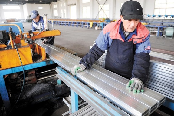 A worker manufacture aluminum products at a factory in Lianyungang, Jiangsu province. The National Bureau of Statistics said on Thursday that year-on-year industrial output growth slowed to 8.6 percent in January and February, down from 9.7 percent in December. PROVIDED TO CHINA DAILY  