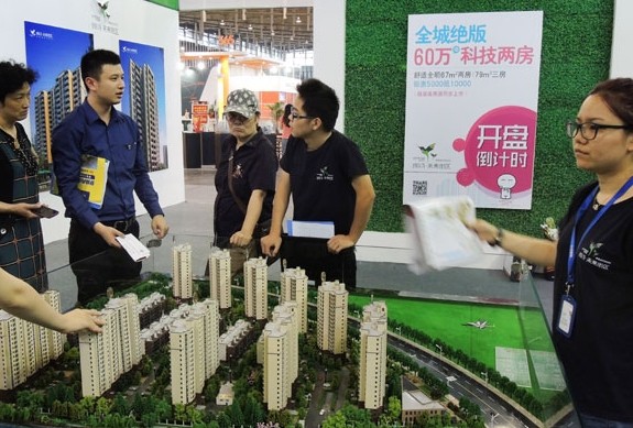 Potential homebuyers look at models of residential property at a developer's showroom in Nanjing, Jiangsu province. CHINA DAILY