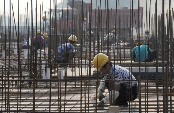 Workers working at a government-supported affordable housing project in Gu'an, Hebei province. An audit found that at the end of June last year, local government debt stood at 17.89 trillion yuan ($2.9 trillion). Wang Xiao / Xinhua
