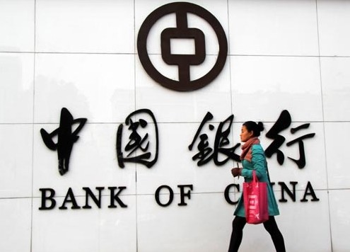 A woman passes a Bank of China branch in Nantong, Jiangsu province. On Wednesday, the nation's fourth-largest lender reported earnings. Xu Ruiping / for China Daily  