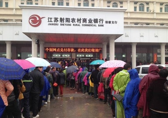 A recent run on a branch office of a local bank in Sheyang, Jiangsu province, reportedly on a rumor about the bank's financial state, while the bank branch was using its bulletin board assuring the customers that it still had an abundant cash reserve. JIANG ZHENJUN / FOR CHINA DAILY  