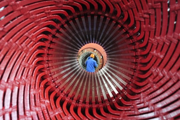 A worker installs rotor coil at a CITIC Heavy Industries Co Ltd plant in Luoyang, Henan province. The HSBC Purchasing Managers'Index slipped to 48 in March from 48.5 in February. Huang Zhengwei / For China Daily  