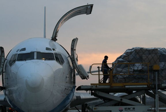 Workers load cargo onto an airplane in Nantong, Jiangsu province. China's non-manufacturing Purchasing Managers'Index in March fell slightly to 54.4 from 55 in February. [Photo/China Daily]  