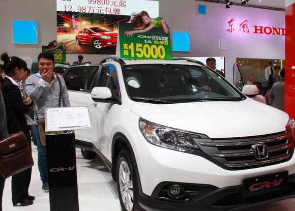 Visitors check a Honda CR-V at an auto show in Haikou, Hainan province. Honda Motor Co said its March sales in China dipped 2 percent to about 60,000 vehicles. Shi Yan / For China Daily   