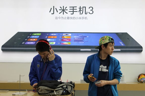 Customers try out Mi3 smartphones at a flagship store of Xiaomi in Wuhan city, Central China's Hubei province, March 30, 2014. Sun Xinming for China Daily  