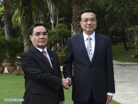 Chinese Premier Li Keqiang (R) shakes hands with Lao Prime Minister Thongsing Thammavong before their talks in Sanya, capital of south China's Hainan Province, April 8, 2014. (Xinhua/Li Xueren)