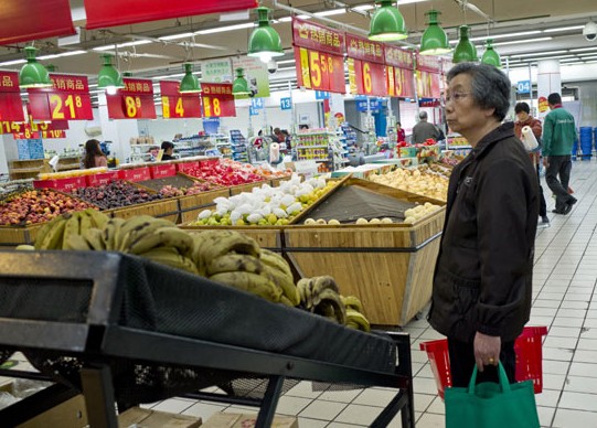 A customer shops at Wal-Mart's Zhaohui store in Hangzhou on Tuesday. Wal-Mart, the world's largest retailer by revenue, decided to shut down more than 20 outlets in China this year. LI ZHENYU/CHINA DAILY  