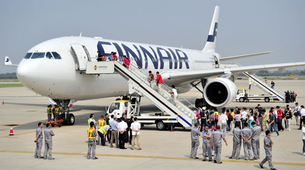 Tourist board a Finnair flight at the Xi'an airport.The online travel industry in China may see consolidation this year. (Yuan Jingzhi / China Daily)