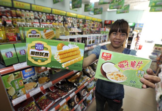 A saleswoman at a convenience store in Haikou, Hainan province, shows snacks similar to those bought by Premier Li Keqiang on Friday when he visited the store. They cost 19 yuan ($3.05). LUO YUNFEI/CHINA NEWS SERVICE  