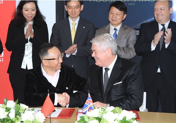 Yuan Yafei, front left, chairman of Sanpower Group, shakes hands with Don McCarthy, front right, chairman of House of Fraser, at a signing event in London for Sanpower acquiring House of Fraser. for CHINA DAILY  