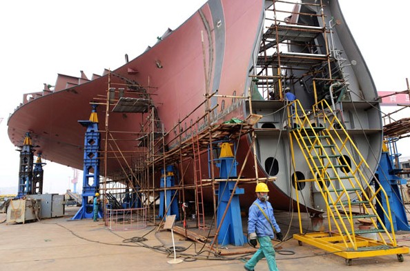 A cargo vessel is under construction in Qingdao Beihai Shipbuilding Heavy Industry Co Ltd in Qingdao, Shandong province. The preliminary HSBC PMI reading for manufacturing was 48.3 in April, compared with 48.0 in March. Yu Fangping / For China Daily  