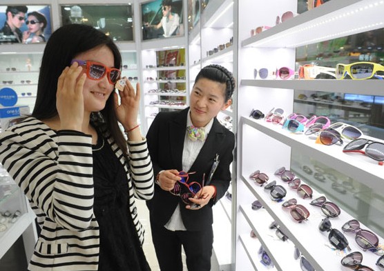 A customer chooses sunglasses in a department store in Fuyang, Anhui province. Consumers in China's second- and third-tier cities are now the primary drivers of consumption growth. Wang Biao / For China Daily  