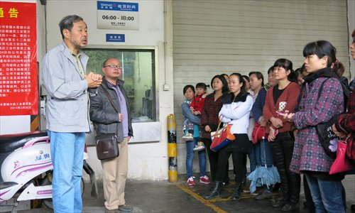 Professor Chang Kai (L) speaks to the laid-off Wal-Mart workers as Huang Xingguo (second from left) listens during a meeting before the labor union submits their second arbitration application on April 21.