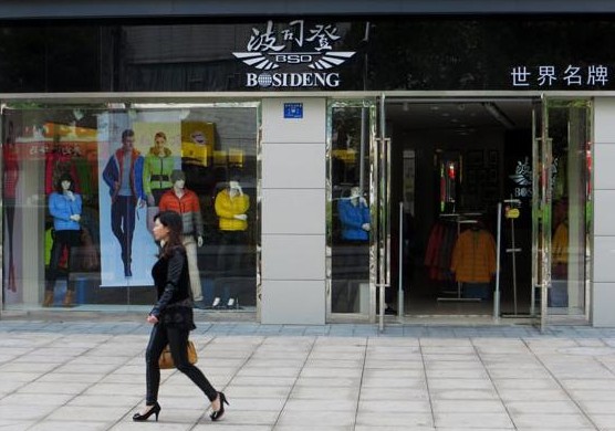 A woman walks past a Bosideng International Holdings Ltd store in Yichang, in Central China's Hubei province. Liu Junfeng / for China Daily  
