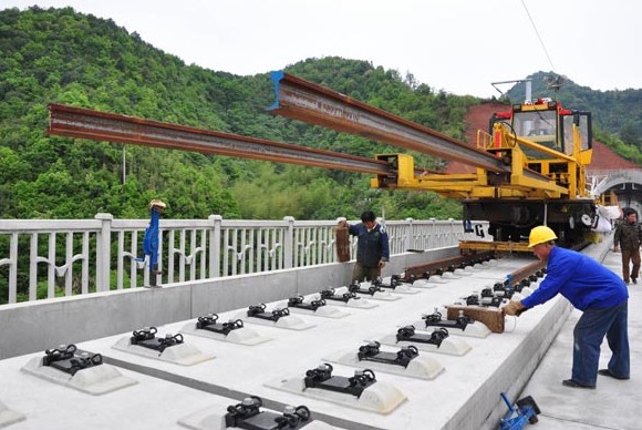 Workers lay tracks for a high-speed rail in Wuyuan county in Jiangxi province. A State Information Center report on Monday suggested speeding up investment in urban renovation and rail projects in central and western China. Hu Dunhuang / for China Daily