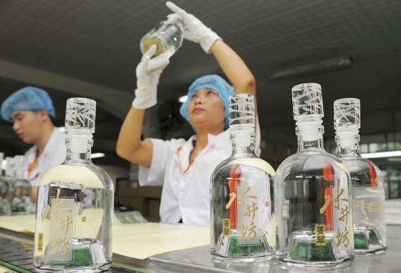 Workers check bottled liquor at Shui Jing Fang Group in Chengdu, Sichuan province. The group saw a loss of 85 million yuan ($13.7 million)in the first three months of 2014 and is forecast to report a loss for the full year. XINHUA  