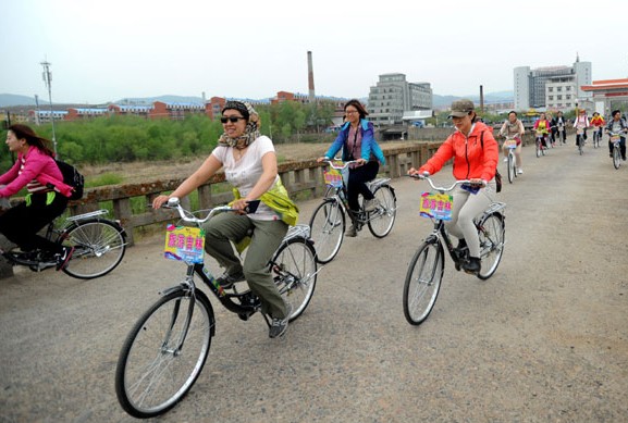 The first group of 35 Chinese cyclists enter the Democratic People's Republic of Korea via Tumen port in Jilin on Friday, after Tumen opened a one-day tour taking visitors to the DPRK. During the six-hour tour, the cyclists visited the Nanyo railway station and a statue of Kim Il-sung. [Photo/Xinhua]