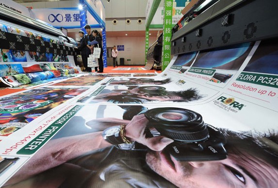An exhibitor displays portrait printing equipment at an advertising expo in Chongqing. Sales of China's Internet advertising reached 63.9 billion yuan ($10.23 billion) last year, a surge of 45.9 percent year on year. Li Jian / Xinhua  