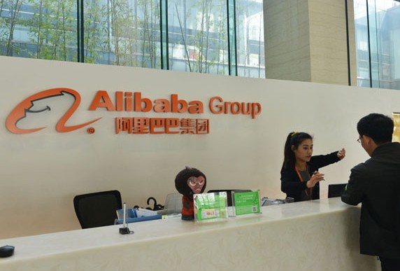 An employee of Alibaba Group answers questions from a visitor in the group's headquarter in Hangzhou, Zhejiang province. Alibaba seeks to raise at least $1 billion through an IPO in the US. Long Wei / For China Daily  