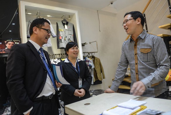 Client managers from Bank of Taizhou visit a clothing vendor to ask about his loan needs in Taizhou, Zhejiang province. New yuan loans amounted to 774.7 billion yuan ($124.95 billion) in April, down from March's 1.05 trillion yuan. HAN CHUANHAO/XINHUA  