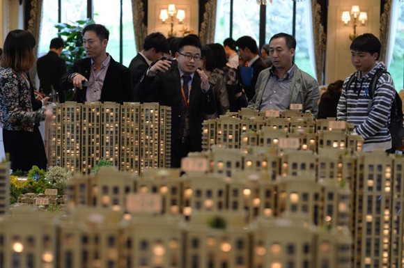 Home buyers examine a property model in Zhuozhou, Hebei province. China's home sales fell 18 percent in April. [Photo/Xinhua]  