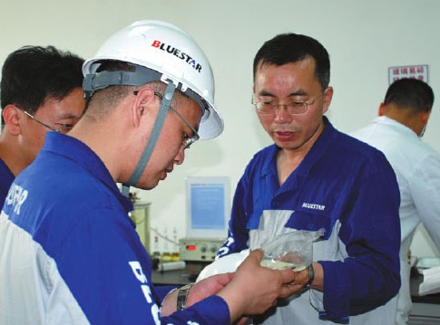 Wang Fengde (second from right), vice-director of China Bluestar Chengrand Chemical Co Ltd, tests products together with researchers. Provided to China Daily  