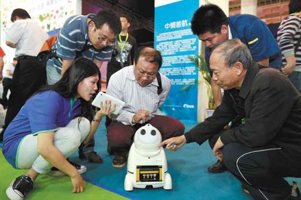 Visitors examine a robot made by Zhongguancun-based Zhinengjia Technology Co. Feng Yongbin / China Daily