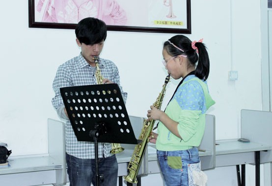 Two youngsters learn to play the clarinet in Zhouwo town, Hebei province. More than 500 children from primary and middle schools are studying music in the town. Zhang Yu / China Daily  