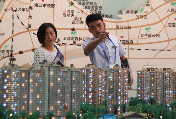 A visitor learns about a housing project at the Hainan Spring Property Exhibition held in Haikou this month. Recent price panics in more and more of China's second- and third-tier cities don't signal the start of any bubble-bursting process generally, according to economist Mike Bastin. SHI YAN/CHINA DAILY  