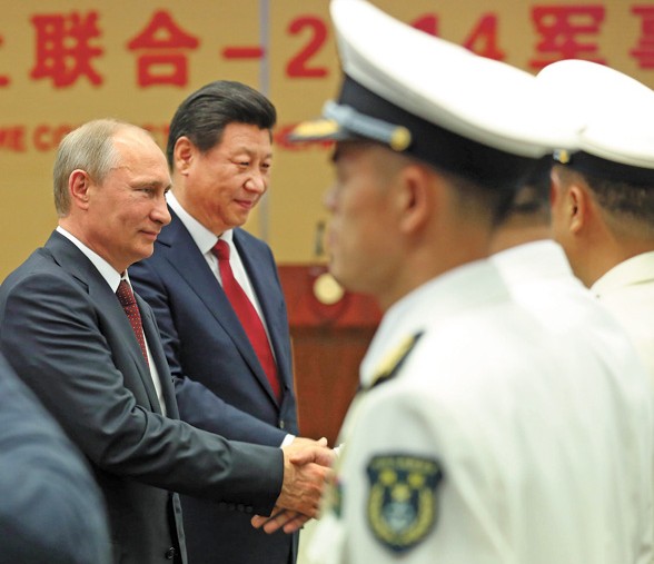 President Xi Jinping and his Russian counterpart Vladimir Putin attend the opening of a joint drill between the countries navies in Shanghai on Tuesday. The exercise in the northern part of the East China Sea will last for a week. [Photo by Wu Zhiyi/China Daily]  