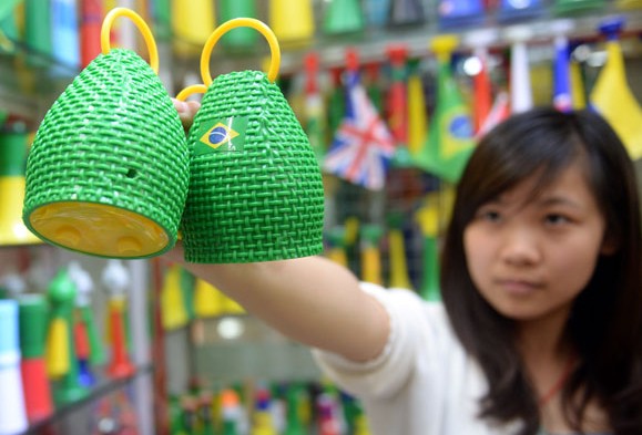 A shop-owner at the Yiwu Small Commodity Market in Zhejiang province demonstrates a pair of caxirolas, the official instrument for soccer fans to cheer for their favorite teams at the 2014 FIFA World Cup in Brazil. More than 90%of caxirolas are made in Guangdong and Zhejiang provinces. Xinhua  