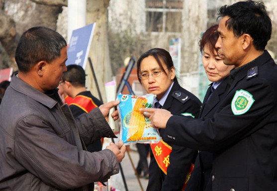 Law enforcement staff from Wanrong county, Shanxi province, tell a farmer how to distinguish fake corn seed. Nearly 70 percent of corn seed sold in China is counterfeit, according to Li Shihua, general manager of Bayan Jianong Agriculture Co Ltd. Provided for China Daily  