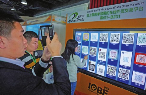 Visitors try two-dimensional code services at an international e-commerce expo in Guangzhou. A number of Chinese cities, including Chengdu, capital of Sichuan province, are promoting e-commerce as a new and vital means to enhance their local economy. Zou Zhongpin / China Daily  